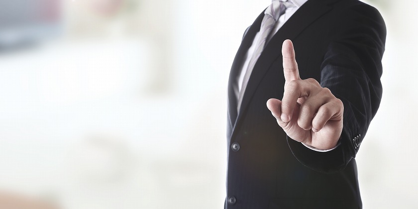 人差し指を出すスーツの男性